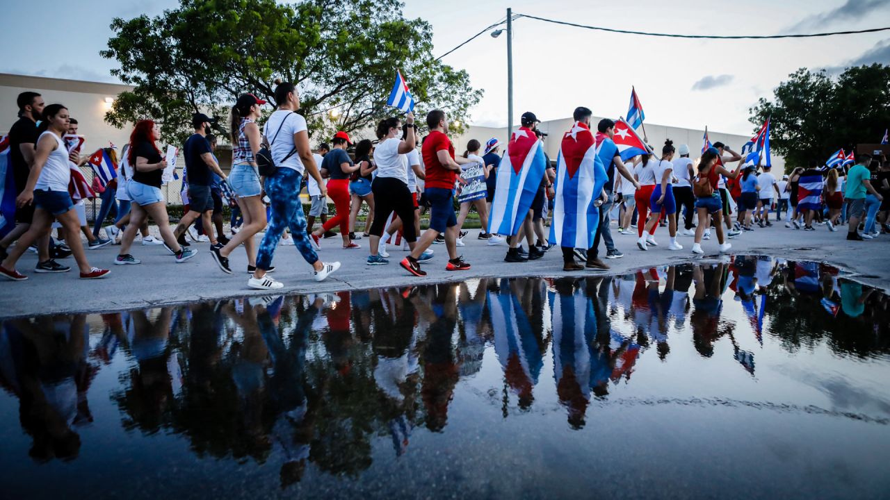 Personas sostienen banderas cubanas y estadounidenses mientras marchan durante una protesta que muestra el apoyo a los cubanos que se manifiestan contra su gobierno, en Hialeah, Florida. | Foto:Eva Marie Uzcategui / AFP