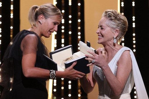 Sharon Stone entrega a Julia Ducournau la Palma de Oro de Cannes 2021. Ella es la segunda cineasta mujer en ganar el premio mayor en la historia el Festival de Cannes.