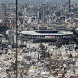 Una mujer toma fotos del Estadio Olímpico desde la plataforma de observación Shibuya Sky en Tokio antes de los Juegos Olímpicos de Tokio 2020. | Foto:Behrouz Mehri / AFP