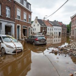 Coches dañados, escombros y ladrillos esparcidos por la calle, tras las fuertes lluvias que han causado graves inundaciones en la zona, en Pepinster. | Foto:Nicolas Maeterlinck / BELGA / AFP