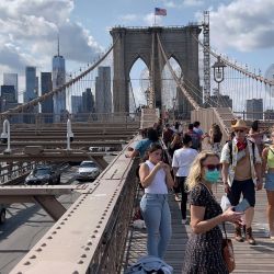 La gente se ve cruzando la pasarela peatonal del puente de Brooklyn en Nueva York. | Foto:Daniel Slim / AFP