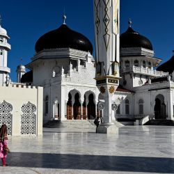 Una mujer y su hijo caminan junto a la Gran Mezquita de Baiturrahman durante el festival Eid al-Adha en Banda Aceh Aceh. | Foto:Chideer Mahyuddin / AFP