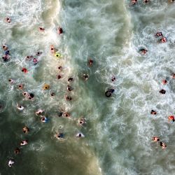 Esta vista aérea muestra a palestinos nadando en el Mediterráneo en medio de las altas temperaturas del verano, en la orilla de la ciudad de Gaza. | Foto:Mohammed Abed / AFP