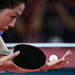 La singapurense Yu MengYu sirve a la japonesa Mima Ito durante el partido de tenis de mesa individual femenino por la medalla de bronce en el Gimnasio Metropolitano de Tokio durante los Juegos Olímpicos de Tokio 2020 en Tokio. | Foto:Anne-Christine Poujoulat / AFP