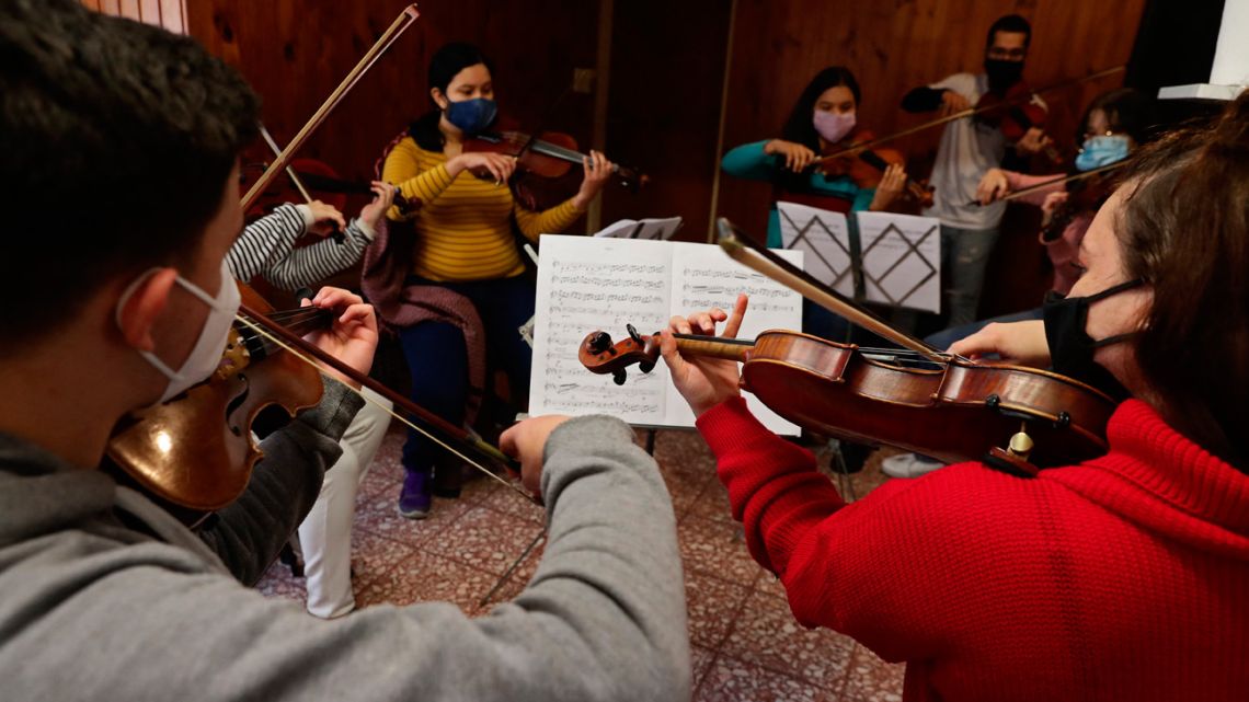 Venezuelan musicians, members of the Latin Vox Machine orchestra, perform 'El Principito Symphonic' during a rehearsal at a house in Buenos Aires, on July 25, 2021. 