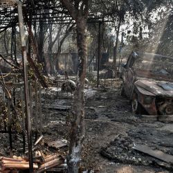 Esta fotografía muestra coches y edificios quemados en Tatoi-Acharnes, al norte de Atenas, al producirse un incendio al pie del monte Parnes, a 30 kilómetros al norte de Atenas. | Foto:Louisa Gouliamaki / AFP