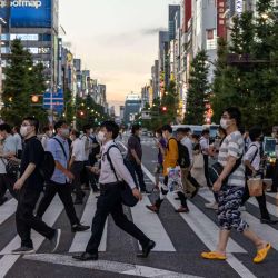 La gente camina por la calle mientras se mantiene el estado de emergencia por coronavirus durante los Juegos Olímpicos de Tokio 2020 en Akihabara, distrito de Tokio. | Foto:Yuki Iwamura / AFP