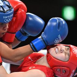 La japonesa Tsukimi Namiki (de rojo) y la brasileña Graziele Sousa luchan durante su combate de boxeo de octavos de final de la categoría mosca femenina (48-51 kg) durante los Juegos Olímpicos de Tokio 2020 en el Kokugikan Arena en Tokio. | Foto:Luis Robayo / POOL / AFP