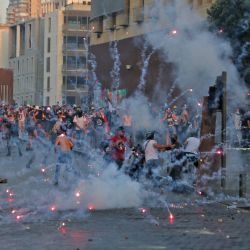 Manifestantes y periodistas huyen de la explosión de fuegos artificiales durante los enfrentamientos con las fuerzas de seguridad cerca de la sede del Parlamento libanés en el centro de la capital, Beirut, en el primer aniversario de la explosión que asoló el puerto y la ciudad. | Foto:AFP