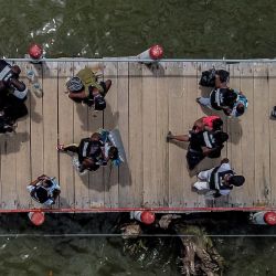 Vista aérea de los migrantes varados de Cuba, Haití y varios países africanos antes de abordar un barco en un muelle en Necoclí, Colombia. | Foto:Joaquin Sarmiento / AFP