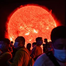 Una representación del sol se ve mientras la gente visita el recién inaugurado Planetario de Shanghai. | Foto:Hector Retamal / AFP