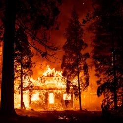 Una casa arde mientras las llamas del incendio Dixie arrasan el barrio de Indian Falls, California. | Foto:Josh Edelson / AFP