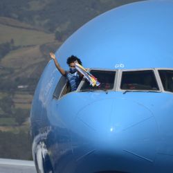La medallista de oro ecuatoriana Neisi Patricia Dajomes Barrera saluda desde la cabina del avión de la aerolínea KLM a su llegada al aeropuerto Mariscal Sucre de Quito. | Foto:Rodrigo Buendia / AFP