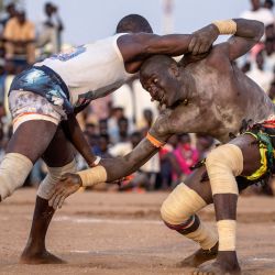 Luchadores compiten durante una competición de lucha tradicional nuba en Jartum, capital de Sudán, entre los equipos de las zonas de  | Foto:Abdulmonam Eassa / AFP