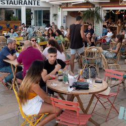 Turistas sentados en la terraza de un restaurante en Cala Estancia en Palma de Mallorca. - La economía española se contrajo bruscamente un 10,8 por ciento en 2020, uno de los peores resultados de la eurozona, con su sector turístico clave golpeado por las restricciones de viaje pandémicas. Pero volvió a crecer en el segundo trimestre de 2021 y el Gobierno prevé que se expandirá un 6,5 por ciento este año. | Foto:Jaime Reina / AFP