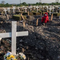 Un enterrador descansa mientras entierra el ataúd de una víctima del coronavirus Covid-19 en un cementerio de Surabaya. | Foto:Juni Kriswanto / AFP