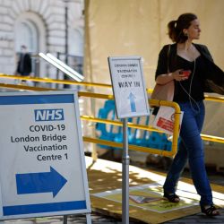 Carteles en la entrada del Centro de Vacunación del Puente de Londres mientras la gente recibe dosis de la vacuna contra el coronavirus Covid-19 en Londres. | Foto:Tolga Akmen / AFP