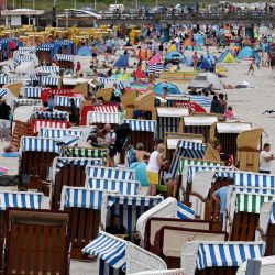 Turistas se bañan en el Mar Báltico y se sientan en sillas de playa en la playa de Binz, en la isla de Ruegen. | Foto:Christof Stache / AFP