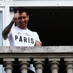 Lionel Messi saluda a los aficionados desde un balcón del hotel Royal Monceau en París, ya que se espera que la leyenda del fútbol firme un acuerdo inicial de dos años con el club de fútbol París Saint-Germain tras su salida del club de su infancia, el Barcelona. | Foto:Sameer Al-Doumy / AFP