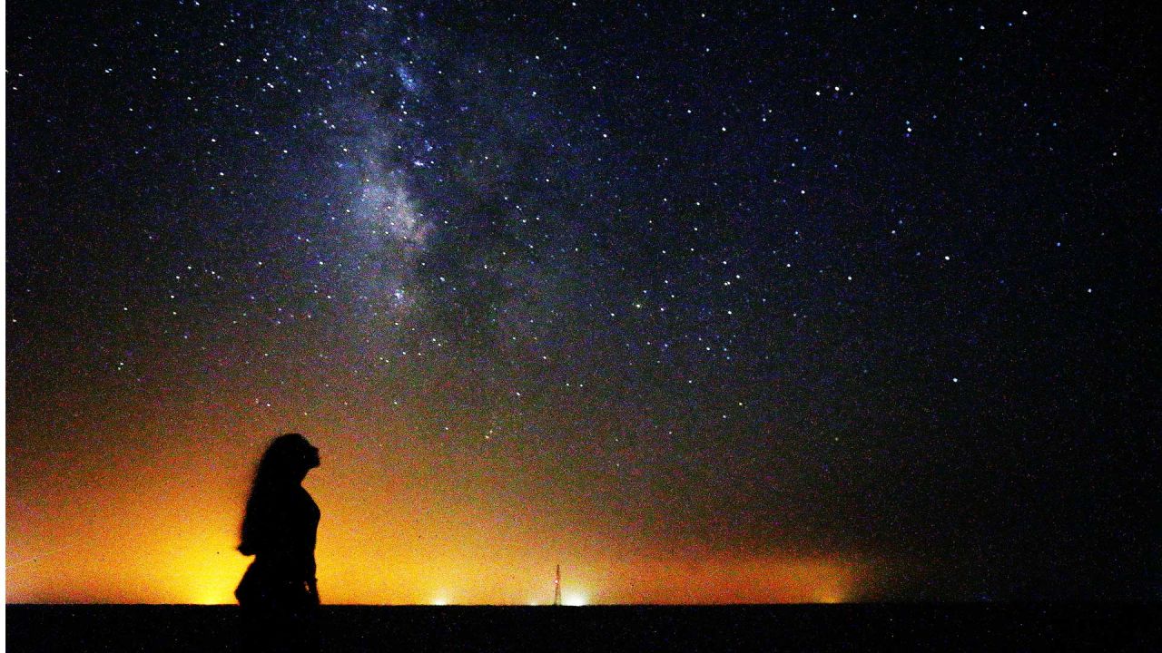 Una mujer observa la galaxia de la Vía Láctea que se eleva en el cielo nocturno en el desierto de al-Salmi en Kuwait, a 120Km al norte de la capital. | Foto:Yasser Al-Zayyat / AFP
