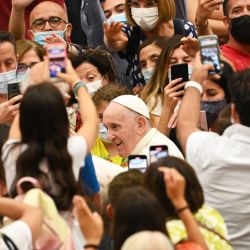 El Papa Francisco es saludado por un fiel al final de su audiencia general semanal en el aula Pablo VI del Vaticano. | Foto:Andreas Solaro / AFP