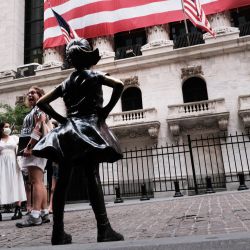 La gente camina junto a la estatua de la Chica Intrépida fuera de la Bolsa de Nueva York en la ciudad de Nueva York. Los mercados subieron en las operaciones de la mañana, ya que los inversores esperan un raro esfuerzo bipartidista en el Senado para aprobar un proyecto de ley de infraestructura masiva que, si se aprueba, infundirá miles de millones en la economía estadounidense. | Foto:Spencer Platt / Getty Images / AFP