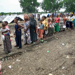 Refugiados etíopes de la etnia Qemant hacen cola para recibir comida en un campamento en la aldea de Basinga, en el distrito de Basunda, en la región oriental de Gedaref, en Sudán. | Foto:Ashraf Shazly / AFP