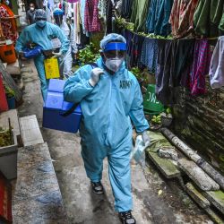 Funcionarios de salud del ejército caminan por un callejón durante la campaña de vacunación móvil contra el coronavirus Covid-19 para los residentes de una localidad en Colombo. | Foto:Ishara S. Kodikara / AFP