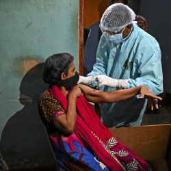 Un funcionario de salud del ejército inocula a una mujer con una dosis del coronavirus Covid-19 durante una campaña de vacunación móvil en Colombo. | Foto:Ishara S. Kodikara / AFP