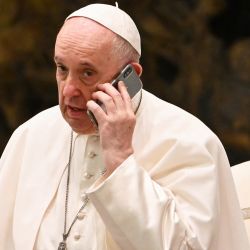 El Papa Francisco habla por teléfono durante su audiencia general semanal el aula Pablo VI del Vaticano. | Foto:Andreas Solaro / AFP