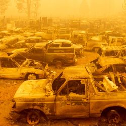 Decenas de vehículos quemados descansan en medio de un intenso humo durante el incendio de Dixie en Greenville, California. | Foto:Josh Edelson / AFP