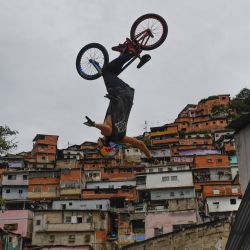 El corredor venezolano de BMX freestyle Daniel Dhers, que ganó la medalla de plata en los Juegos Olímpicos de Tokio 2020, salta con su bicicleta en una rampa durante una exhibición en el barrio de Cota 905, en Caracas. | Foto:Federico Parra / AFP