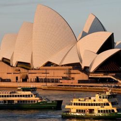 Transbordadores casi vacíos pasan frente a la Casa de la Ópera en Sídney, mientras la mayor ciudad de Australia anunció restricciones más estrictas de Covid, incluyendo multas más fuertes y una mayor vigilancia para contener un brote de Delta. | Foto:Saeed Khan / AFP