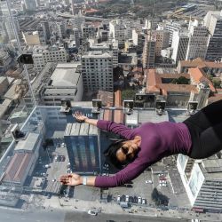 Una visitante se divierte en el mirador Sampa Sky, en Sao Paulo, Brasil. El mirador Sampa Sky, inaugurado el pasado 8 de agosto, se encuentra en el edificio Mirante do Vale, el rascacielos más alto de la ciudad, sobre una estructura de vidrio a 150 metros de altura que da la sensación a los visitantes de flotar. | Foto:Xinhua / Rahel Patrasso