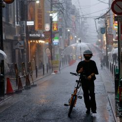 Los peatones caminan con paraguas durante las fuertes lluvias en Osaka. | Foto:David Gannon/ AFP