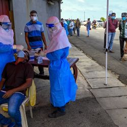 Un trabajador sanitario recoge una muestra de un hombre para analizar el coronavirus Covid-19 en Colombo. | Foto:Ishara S. Kodikara / AFP