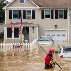 Un miembro del equipo de rescate de la Compañía de Bomberos Voluntarios de New Market vadea las aguas altas tras una inundación repentina, mientras la tormenta tropical Henri toca tierra, en Helmetta, Nueva Jersey. | Foto:Tom Brenner / AFP