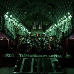 La tripulación de la Fuerza Aérea de los Estados Unidos, asiste a los evacuados calificados a bordo de un avión C-17 Globemaster III, en apoyo de la evacuación de Afganistán en el Aeropuerto Internacional Hamid Karzai, Kabul, Afganistán. | Foto:aylor Crul / US AIR FORCE / AFP