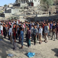 Estudiantes yemeníes asisten a la llamada de la mañana antes del comienzo de las clases en edificios residenciales y comerciales inacabados convertidos en escuela y aulas. | Foto:Ahmad AL-Basha / AFP