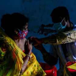 Un trabajador sanitario inocula a una mujer la dosis de la vacuna contra el coronavirus Covishield Covid-19 en un campamento de vacunación gratuito en Siliguri. | Foto:Diptendu Dutta / AFP