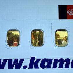 Los pasajeros miran a través de las ventanas de un avión de pasajeros Boeing 737-31S de Kam Air con personas evacuadas de Afganistán a bordo en el aeropuerto internacional de Boryspil, a las afueras de Kiev. | Foto:Sergei Gapon / AFP