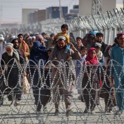 Afganos caminan junto a las vallas mientras llegan a Pakistán a través del puesto fronterizo entre Pakistán y Afganistán en Chaman tras la toma militar de Afganistán por parte de los talibanes. | Foto:AFP