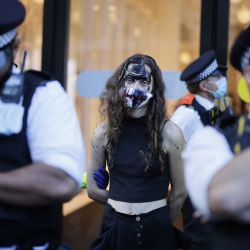 Agentes de policía detienen a un activista climático del grupo Extinction Rebellion frente a la tienda Selfridges en el centro de Londres, donde el grupo se manifestó contra el uso de combustibles fósiles. | Foto:Tolga Akmen / AFP