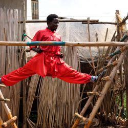 Imagen de Manisuru Ssejjemba realizando estiramientos durante su entrenamiento de artes marciales chinas en un centro de entrenamiento improvisado detrás de su casa, en Katooke, en el norte de Kampala, capital de Uganda. | Foto:Xinhua / Hajarah Nalwadda