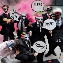 Activistas climáticos de Extinction Rebellion llevan máscaras de rata mientras protestan durante la serie de acciones del grupo  | Foto:Tolga Akmen / AFP