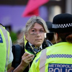 Un activista climático del grupo Extinction Rebellion sostiene un espejo frente a un agente de policía en el cordón de seguridad en medio de Oxford Circus, en el centro de Londres, durante la serie de acciones  | Foto:Tolga Akmen / AFP