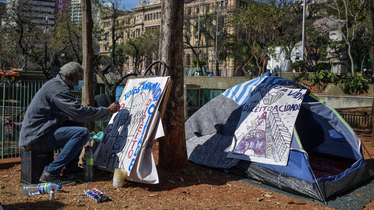 Un indigente pinta un cartel en la Plaza Se, en el centro de Sao Paulo, Brasil. - Sao Paulo se enfrenta a una crisis de personas sin hogar, ya que los precios recientes se convierten en una carga demasiado pesada para una población cada vez más empobrecida. | Foto:NELSON ALMEIDA / AFP