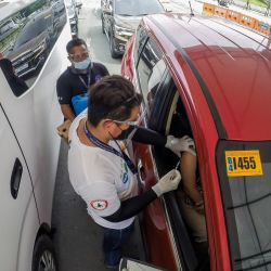 Un trabajador de la salud inocula a un ciudadano con una dosis de una vacuna contra la COVID-19 en un sitio de vacunación a bordo de vehículos, en Manila, Filipinas. | Foto:Xinhua / Rouelle Umali