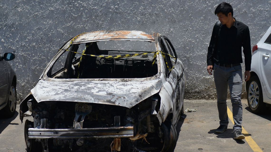 In this file photo taken on December 30, 2016, a man looks at the burned-out rental car of missing Greek ambassador to Brazil Kyriakos Amiridis, at a parking lot outside the police station in Belford Roxo, in the Brazilian state of Rio de Janeiro, a day after it was found with a body inside. A Brazilian court sentenced Françoise de Souza Oliveira to 31 years in prison for murdering her husband, Greek ambassador Kyriakos Amiridis, along with her lover, a military policeman who confessed to the crime and was also convicted. 