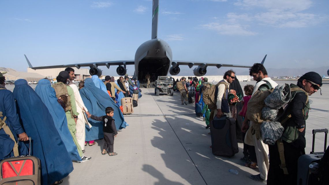 In this file photo taken on August 25, 2021, this handout photo cshows US Air Force loadmasters and pilots assigned to the 816th Expeditionary Airlift Squadron, load passengers aboard a US Air Force C-17 Globemaster III in support of the Afghanistan evacuation at Hamid Karzai International Airport (HKIA), Afghanistan. 